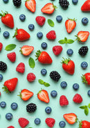 Fresh Mixed Berries and Mint Leaves on Blue Background