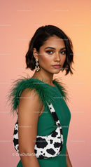 Elegant Woman in Green Dress with Feathered Shoulder and Cow Print Purse