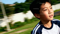 Young boy running outdoors with focused expression