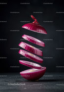 Floating slices of fresh red onion on dark background
