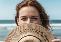 Smiling Young Woman with Straw Hat at the Beach
