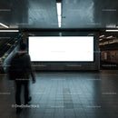 Commuter walking past empty illuminated subway billboard
