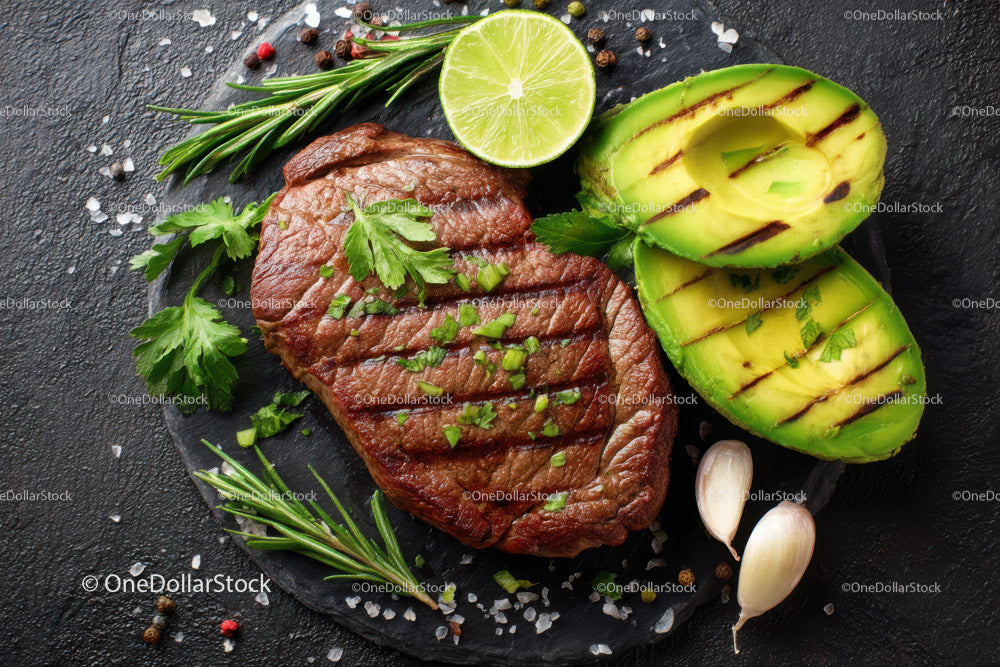 Gourmet Grilled Steak with Sliced Avocado and Fresh Herbs