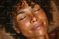 Close-Up of a Woman with Curly Hair and Freckles in Relaxed Mood