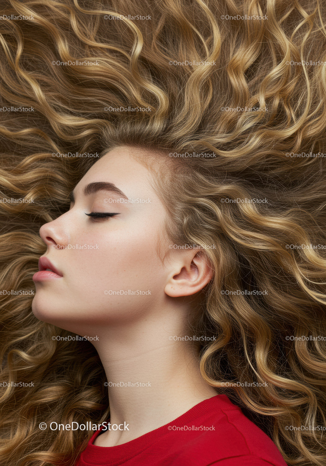 Peaceful young woman with flowing curly hair profile
