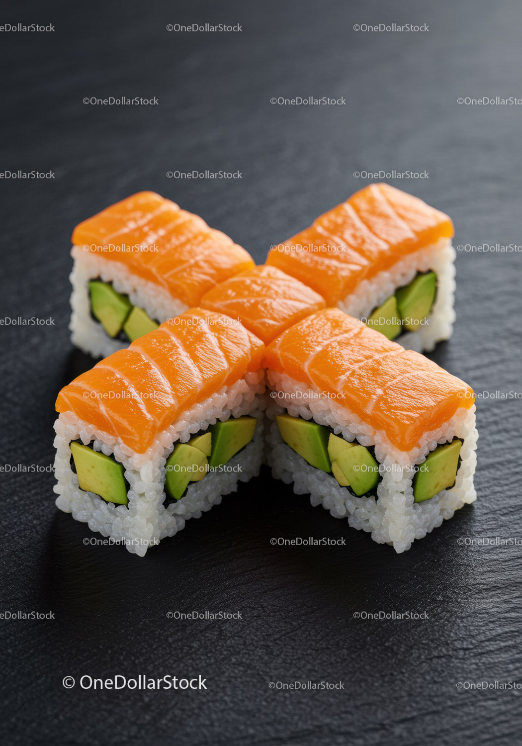 Fresh salmon avocado sushi rolls on black slate