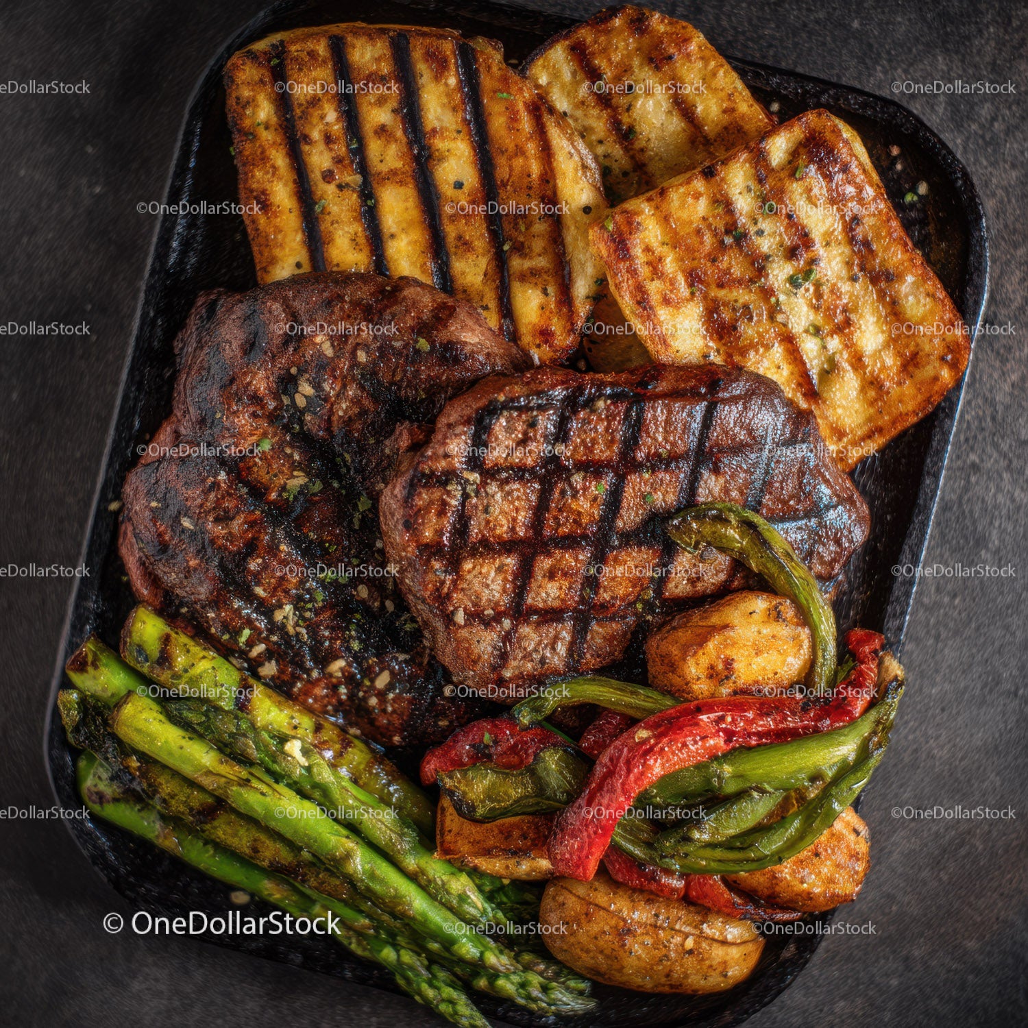 Grilled Steak with Roasted Potatoes and Asparagus in a Black Cast Iron Skillet