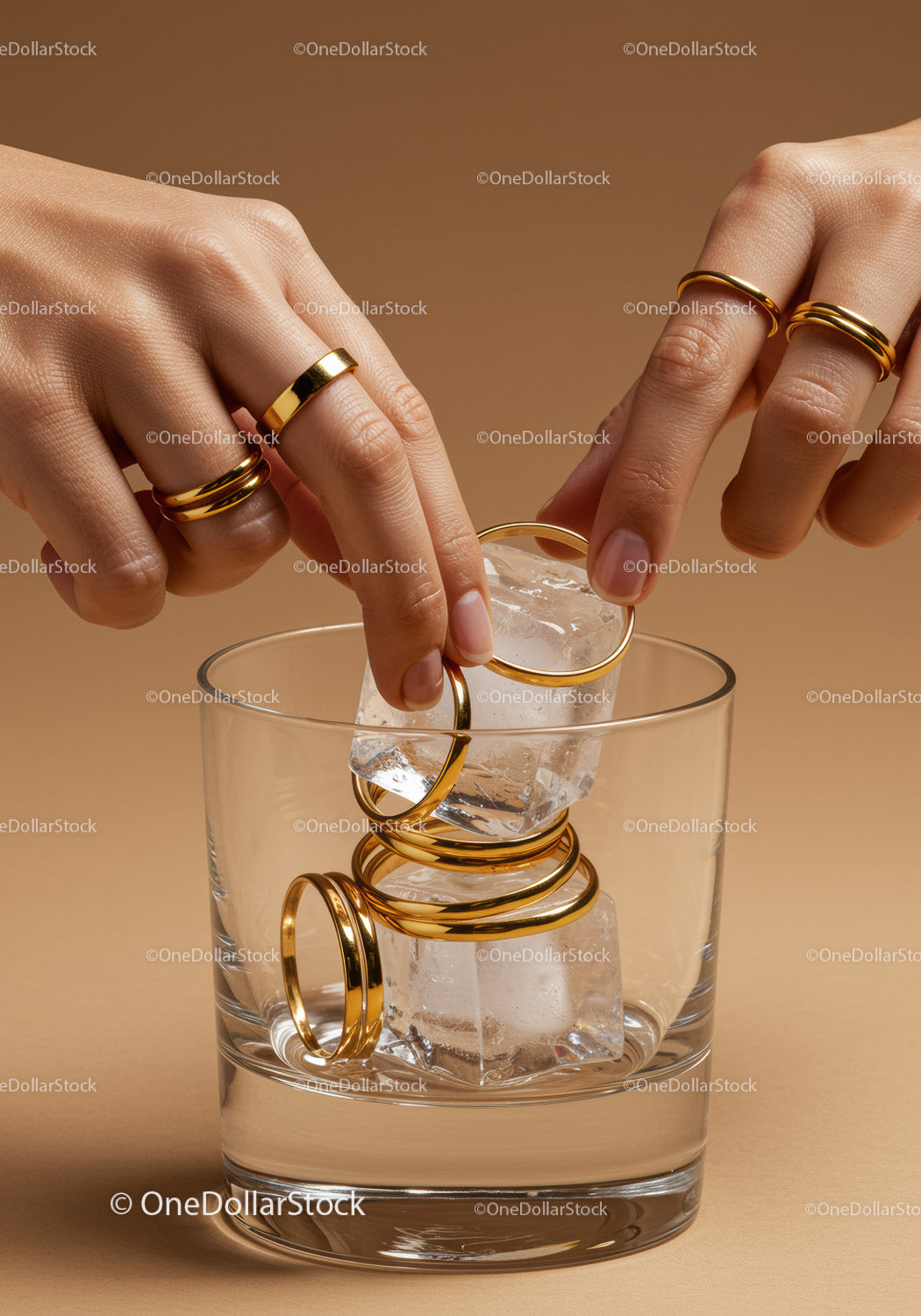 Golden rings placed on ice cubes in a glass