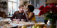 Couple playfully baking heart shaped cookies together