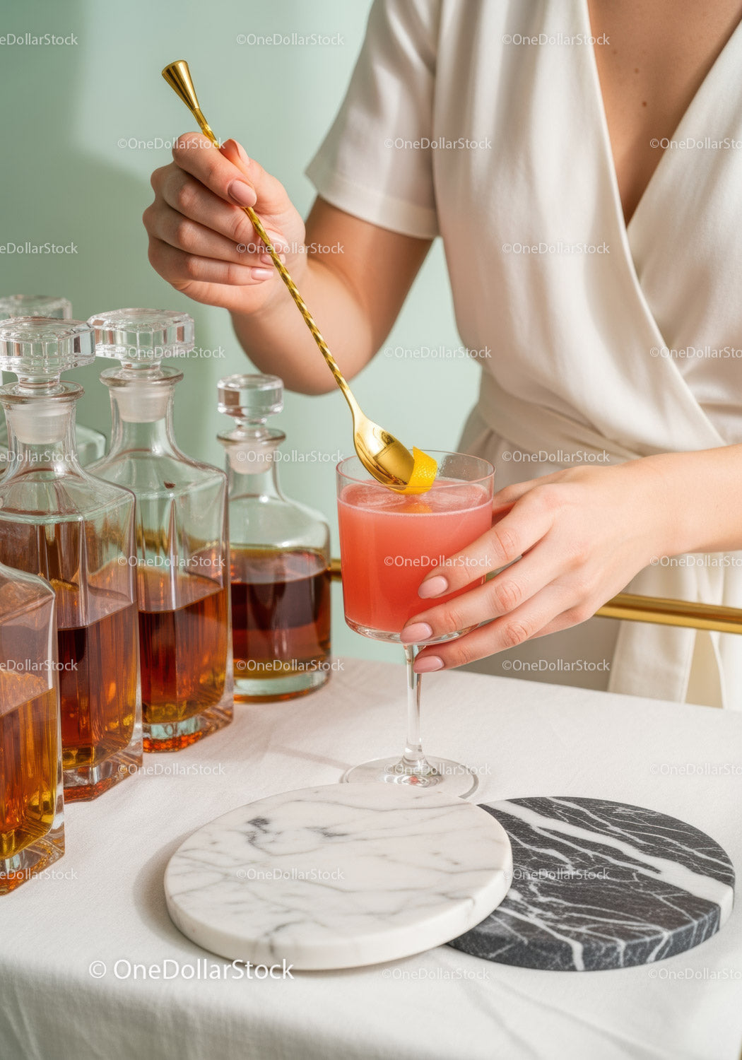 Elegant Cocktail Preparation with Gold Bar Tool and Colorful Drinks