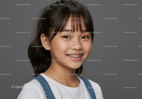 Smiling Young Girl with Braces Wearing Denim Overalls and White T-Shirt