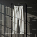 Elegant white tailored trousers hanging on rack