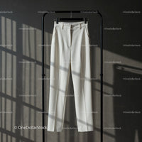 Elegant white tailored trousers hanging on rack
