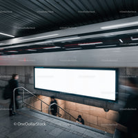 Commuters moving near blank billboard in metro station