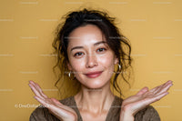 Smiling Woman with Curly Hair and Bright Eyes Against Yellow Background
