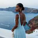 Elegant woman in blue dress overlooking serene sea view