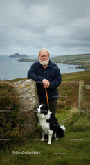 Senior Man with Border Collie Enjoying the Coastal Scenery