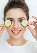 Young Woman with Blue Eyes Smiling and Holding Cucumber Slices