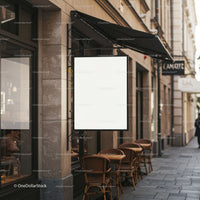 Empty white signboard above cozy outdoor cafe seating
