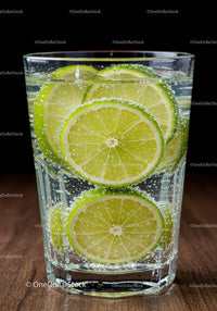 Refreshing sparkling water with lime slices in glass