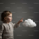 Curious toddler pointing at fluffy white cloud on gray background