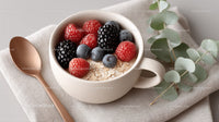 Mixed Berries Over Oatmeal in a White Mug with Green Eucalyptus