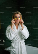 Young Woman in Bathrobe Applying Eye Masks for Skincare Relaxation