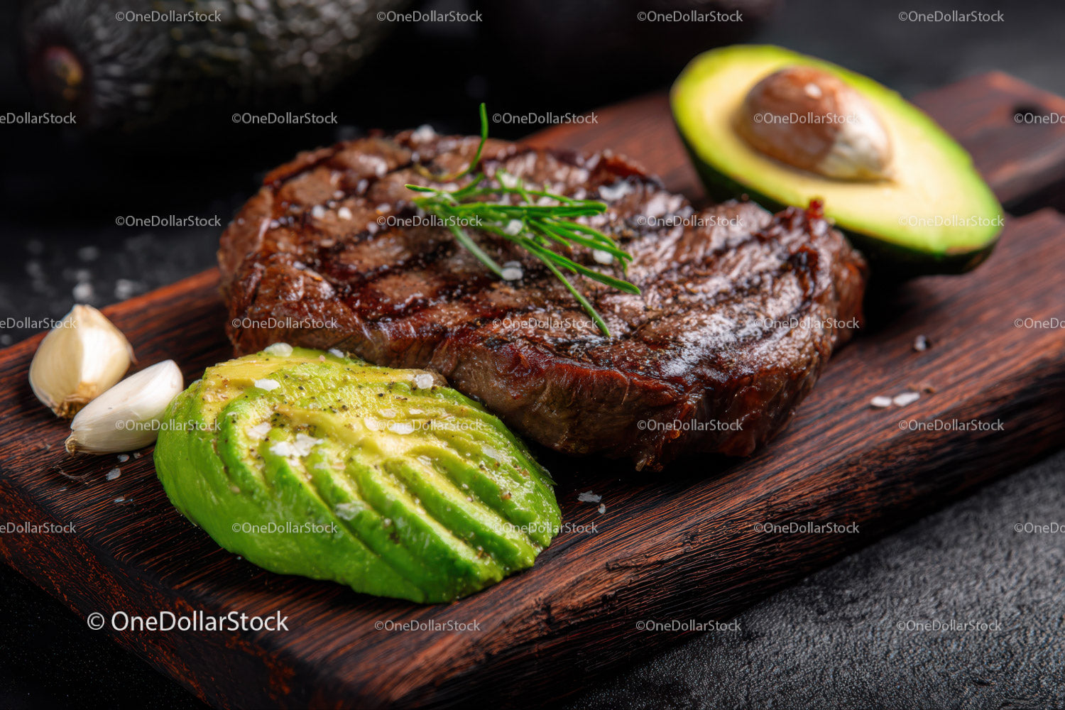 Juicy Grilled Steak with Fresh Avocado Slices and Garlic Cloves