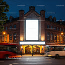 Historic theater facade illuminated at dusk with moving buses