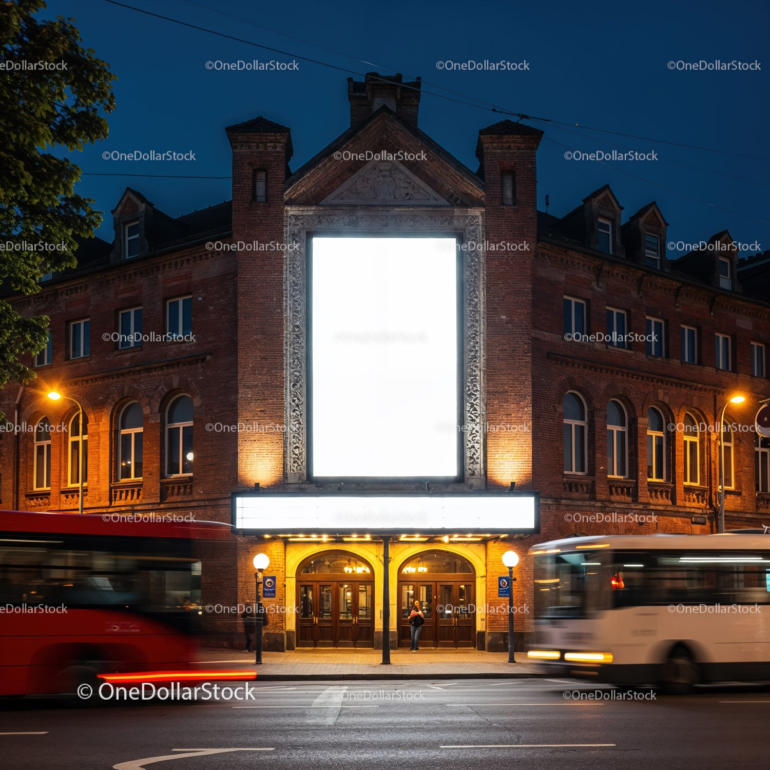 Historyczna fasada teatru oświetlona o zmierzchu przez poruszające się autobusy