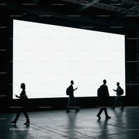 Silhouettes of People Walking by Large Illuminated Screen