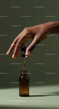 Elegant Hand with Dropper Extracting Oil from Amber Glass Bottle