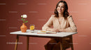 Cheerful Woman Writing at a Table with Flowers and Drinks