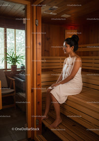 Relaxing Woman Sitting in Sauna Cabin with Wooden Interior