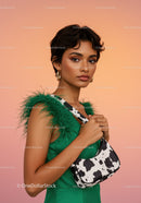 Elegant Woman in Green Dress with Cow Print Handbag and Feathered Accessories