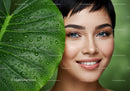Smiling Woman with Bright Eyes and Fresh Green Leaf with Water Droplets