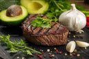 Juicy Grilled Steak with Fresh Avocado and Garlic on Rustic Board