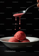 Dripping sauce over vibrant red sorbet scoops in bowl