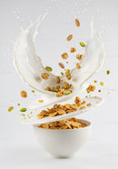 Breakfast cereal with milk splash and nuts in bowl