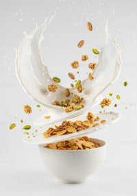 Breakfast cereal with milk splash and nuts in bowl