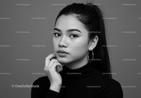 Elegant Black and White Portrait of Confident Young Woman with Hoop Earrings