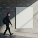 Man walking past empty modern concrete wall with blank canvas