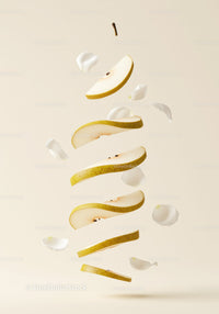 Floating Sliced Pear with White Petals on Soft Background