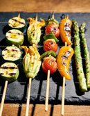 Grilled vegetable skewers with fresh herbs on slate