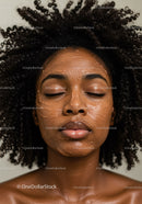 Young woman receiving facial skincare treatment with facial mask