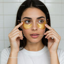 Young Woman Applying Gold Under-Eye Masks for Skin Rejuvenation