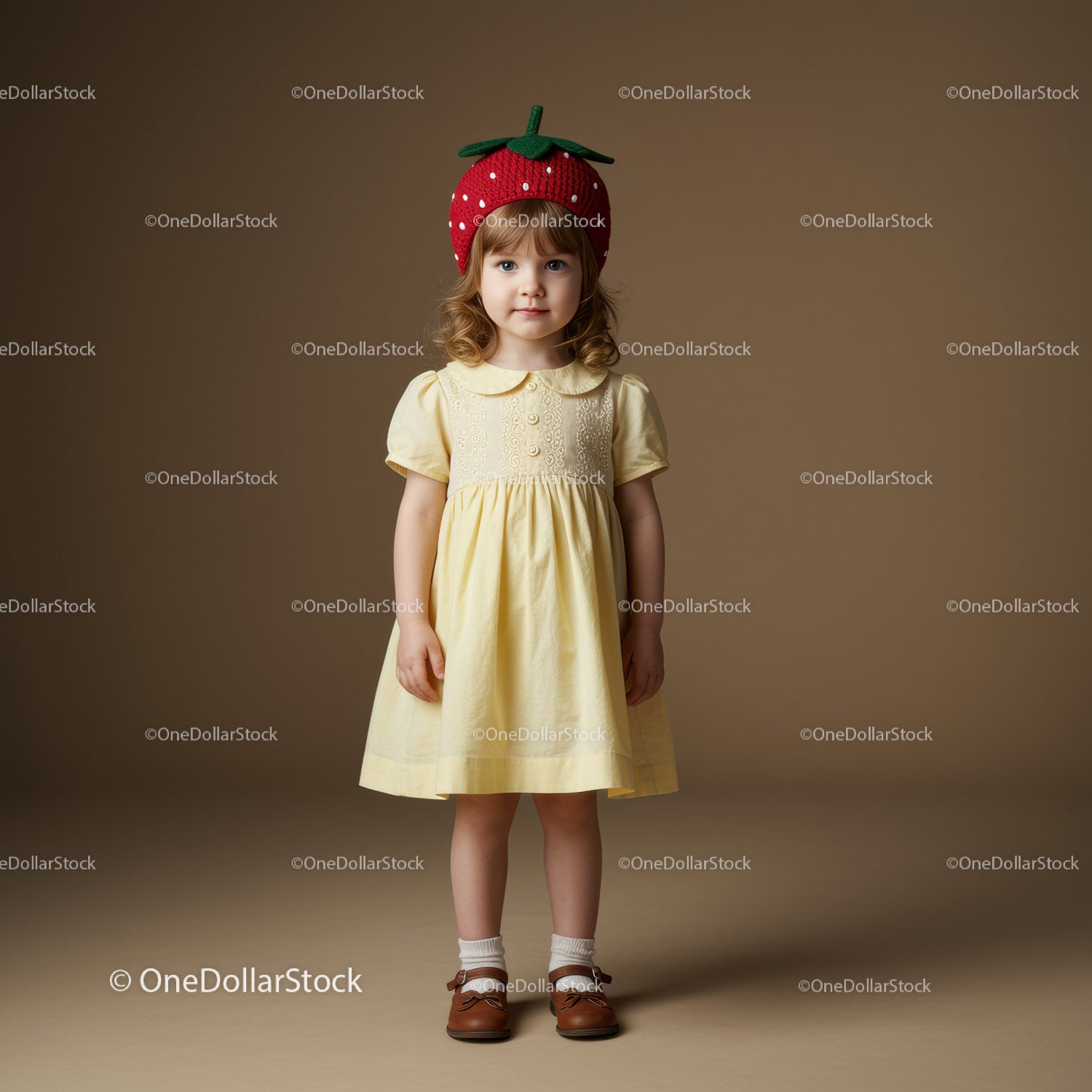 Little girl in yellow dress with strawberry hat