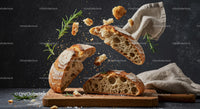 Rustic sourdough bread breaking with fresh rosemary sprigs