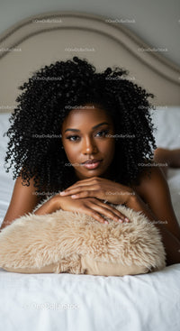 Young woman resting on bed with curly hair and soft pillow