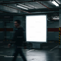 Blurred man walking past illuminated billboard in parking garage